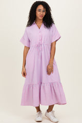 woman wearing a pink and white striped button-up midi dress with short sleeves and a drawstring waist
