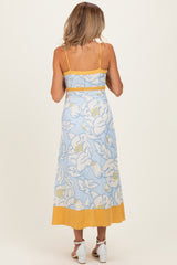 woman wearing a blue floral maternity maxi dress with yellow accents, showing the back view