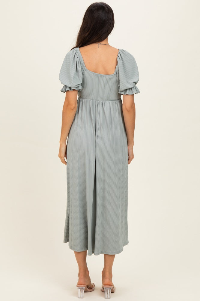 woman wearing a light green pleated midi dress with puff sleeves, seen from the back