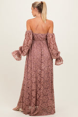 woman wearing a mauve off-the-shoulder lace maternity dress with long puff sleeves and a flowing skirt