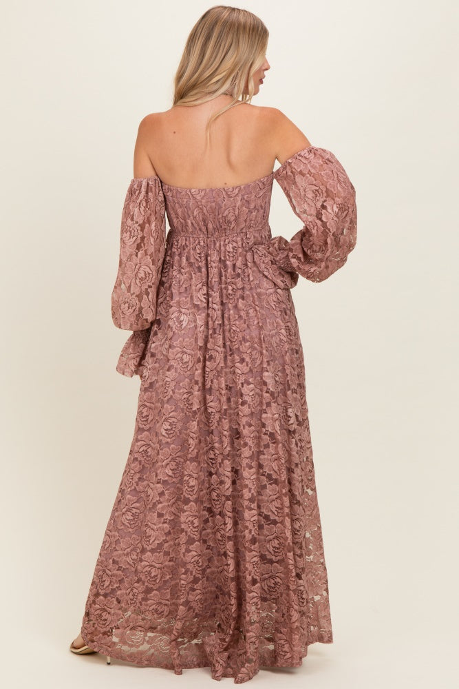 woman wearing a rose pink off-the-shoulder lace maxi dress with long puff sleeves and a fitted waistline