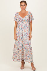 woman wearing a floral maxi dress with short flutter sleeves and a gathered neckline