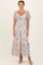 woman wearing a floral maxi dress with short flutter sleeves and a gathered neckline