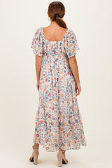 woman wearing a floral maxi dress with short flutter sleeves and a square neckline, view from the back