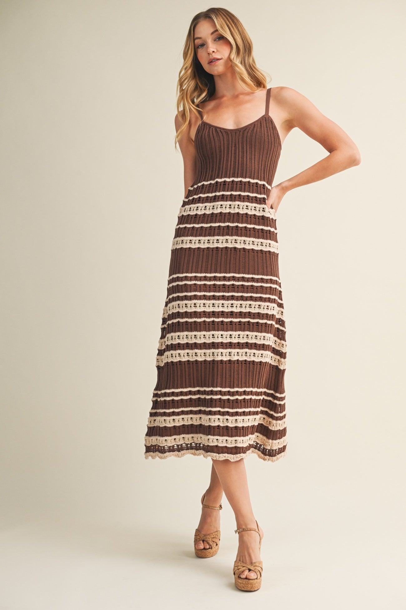 woman wearing a brown and cream striped midi dress with a knitted bodice and adjustable straps