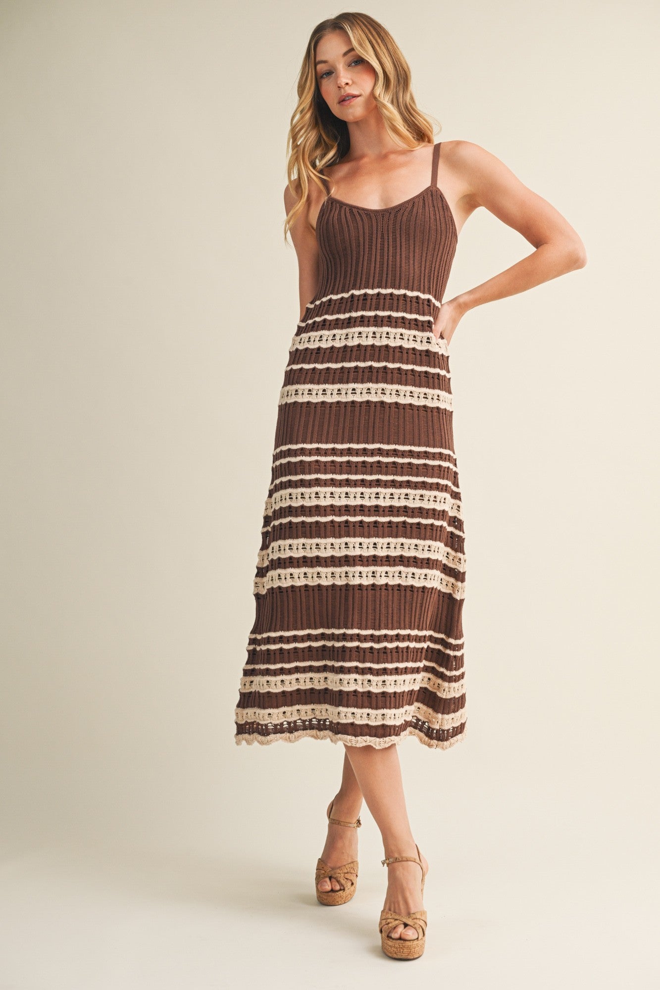 woman wearing a brown and cream striped midi dress with a knitted bodice and adjustable straps