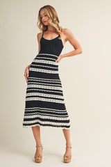 woman wearing a black and white striped ribbed maxi dress with a fitted bodice and flared skirt