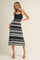 woman wearing a black and white striped ribbed maxi dress with a fitted bodice and flared skirt