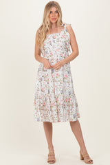 woman wearing a white floral print sundress with spaghetti straps and a tiered skirt
