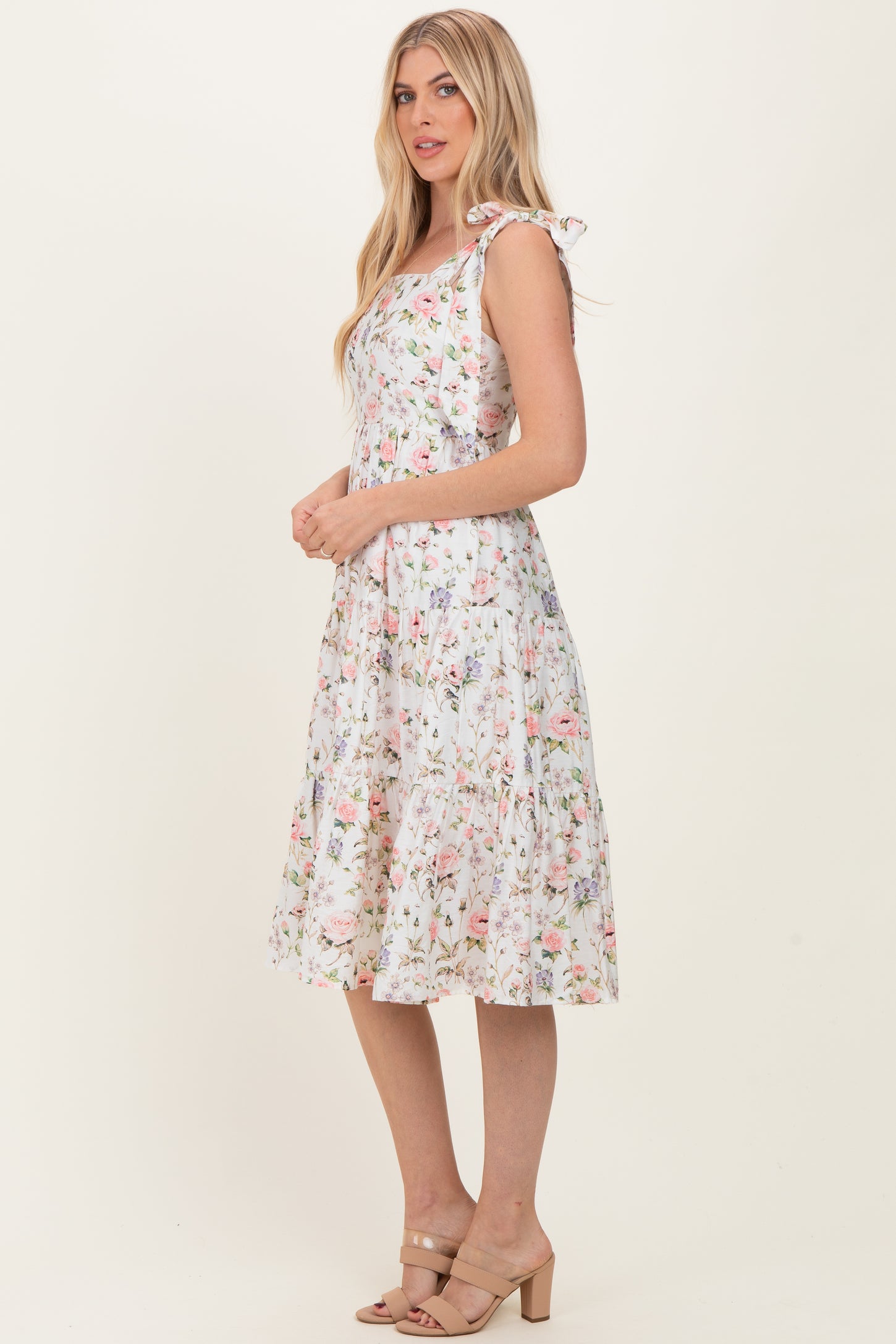 woman wearing a white floral midi dress with tie straps and a tiered skirt
