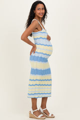 woman wearing a blue and yellow striped maternity dress and showing her baby bump