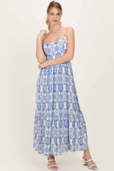 woman wearing a blue and white patterned maxi dress with spaghetti straps and a tiered skirt