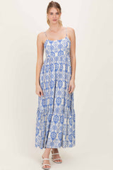 woman wearing a blue and white patterned maxi dress with spaghetti straps and a tiered skirt