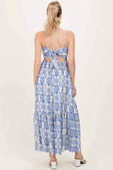 woman wearing a blue and white patterned maxi dress with a tied back and open cutouts