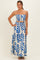woman wearing a strapless maxi dress with a blue leaf print and a matching belted waist