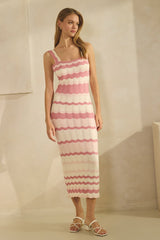 woman wearing a knitted pink and white striped midi dress with a one-shoulder design and ribbed detailing