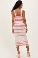 woman wearing a pink and white striped maternity dress with a fitted bodice and midi length, showing her back