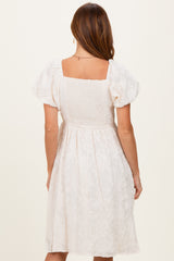 woman wearing a white floral puff sleeve dress with a square back and smocked bodice