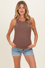 woman wearing a brown and white striped maternity tank top and denim shorts, standing with hands on her hips