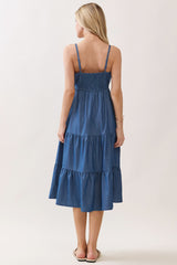 woman wearing a back view of a tiered denim maxi dress with a smocked bodice and adjustable straps