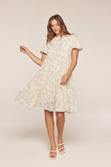 woman wearing a light floral short sleeve dress with a tiered skirt and eyelet details