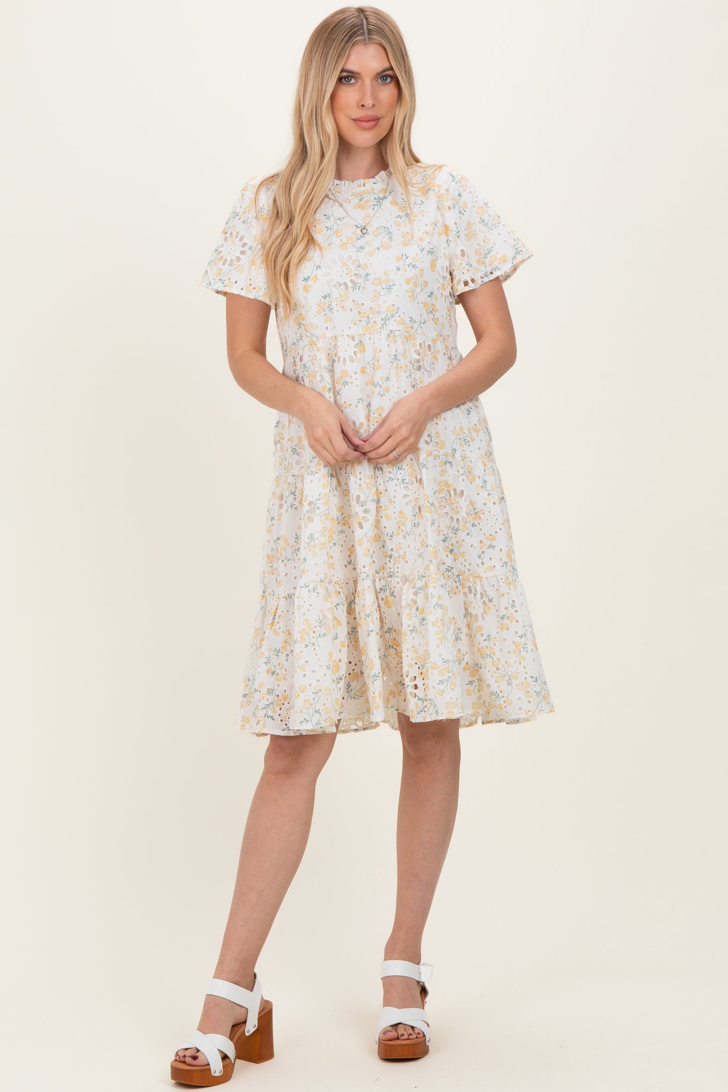 woman wearing a light blue floral print short sleeve dress and brown wedge sandals