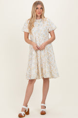 woman wearing a light blue floral print short sleeve dress and brown wedge sandals