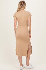woman wearing a tan short sleeve maxi dress with a side slit, showing the back view and styled with white sneakers