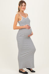 woman wearing a black and white striped maternity maxi dress and holding her baby bump