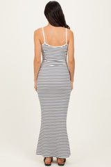woman wearing a fitted black and white striped maxi dress with spaghetti straps