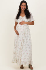 woman wearing a floral print maternity maxi dress and holding her baby bump