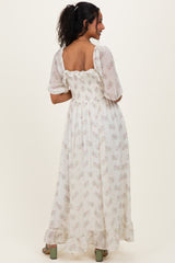 woman wearing a floral maternity maxi dress with a smocked back and ruffled sleeves, showing a baby bump