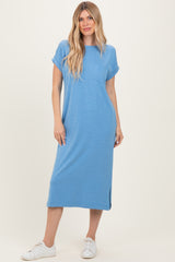 woman wearing a blue short sleeve midi dress with a pocket and side slits, paired with white sneakers