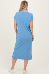 woman wearing a casual blue short sleeve midi dress with side slits and white sneakers