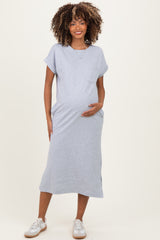 woman wearing a gray short sleeve maternity dress with a pocket and holding her baby bump