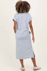 woman wearing a gray short sleeve maternity dress with a side slit, standing with her back to the camera