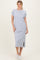 woman wearing a gray midi t-shirt dress with short sleeves and side slits, styled with white sneakers