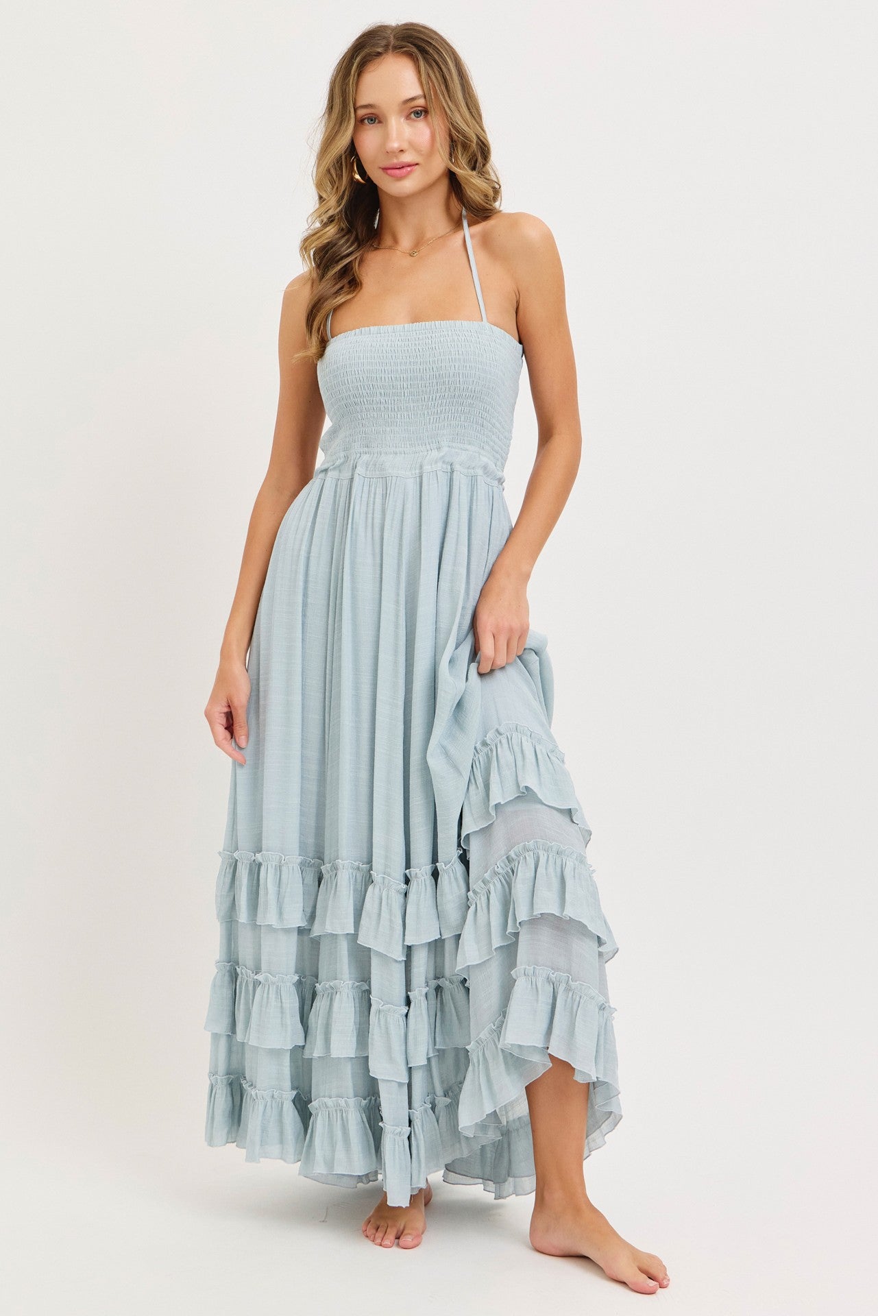 woman wearing a light blue strapless maxi dress with a smocked bodice and ruffled hem