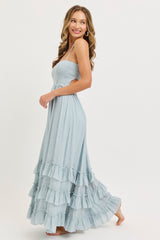 woman wearing a light blue smocked maxi dress with ruffle details and spaghetti straps
