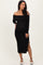 woman wearing a black off-shoulder maternity dress with side slit and holding her baby bump