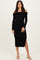 woman wearing a black off-the-shoulder long sleeve dress with a side slit and fitted silhouette