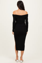 woman wearing a black off-the-shoulder long sleeve dress with a slit, view from the back