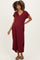 woman wearing a burgundy maternity maxi dress with short sleeves and a v-neck, showing her baby bump