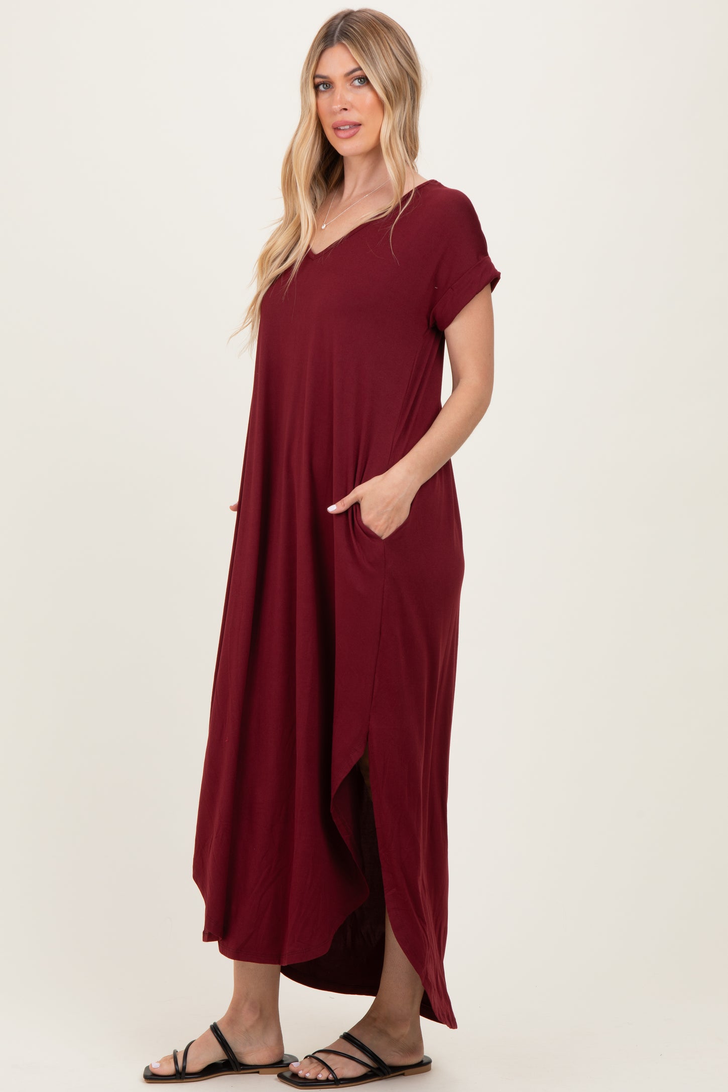 woman wearing a burgundy maxi dress with short sleeves and side pockets