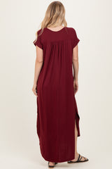 woman wearing a burgundy maxi dress with short sleeves and side slits, shown from the back
