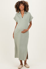 woman wearing a sage green maternity maxi dress with a polo collar and side slits, holding her baby bump