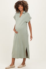woman wearing a sage green maternity dress with a collar and side slits, holding her baby bump