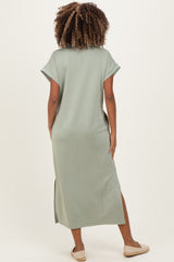 woman wearing a green maternity maxi dress with short sleeves and side slits, showing her back