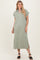 woman wearing a light green short sleeve collared maxi dress with side slits and black sandals