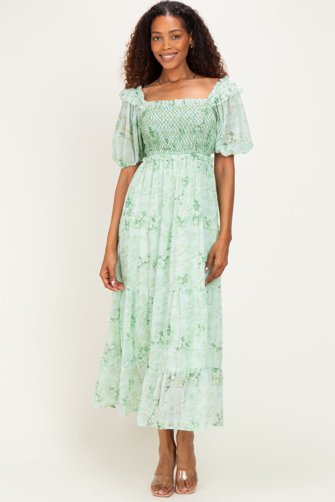 woman wearing a green floral maxi dress with short puff sleeves and smocked bodice